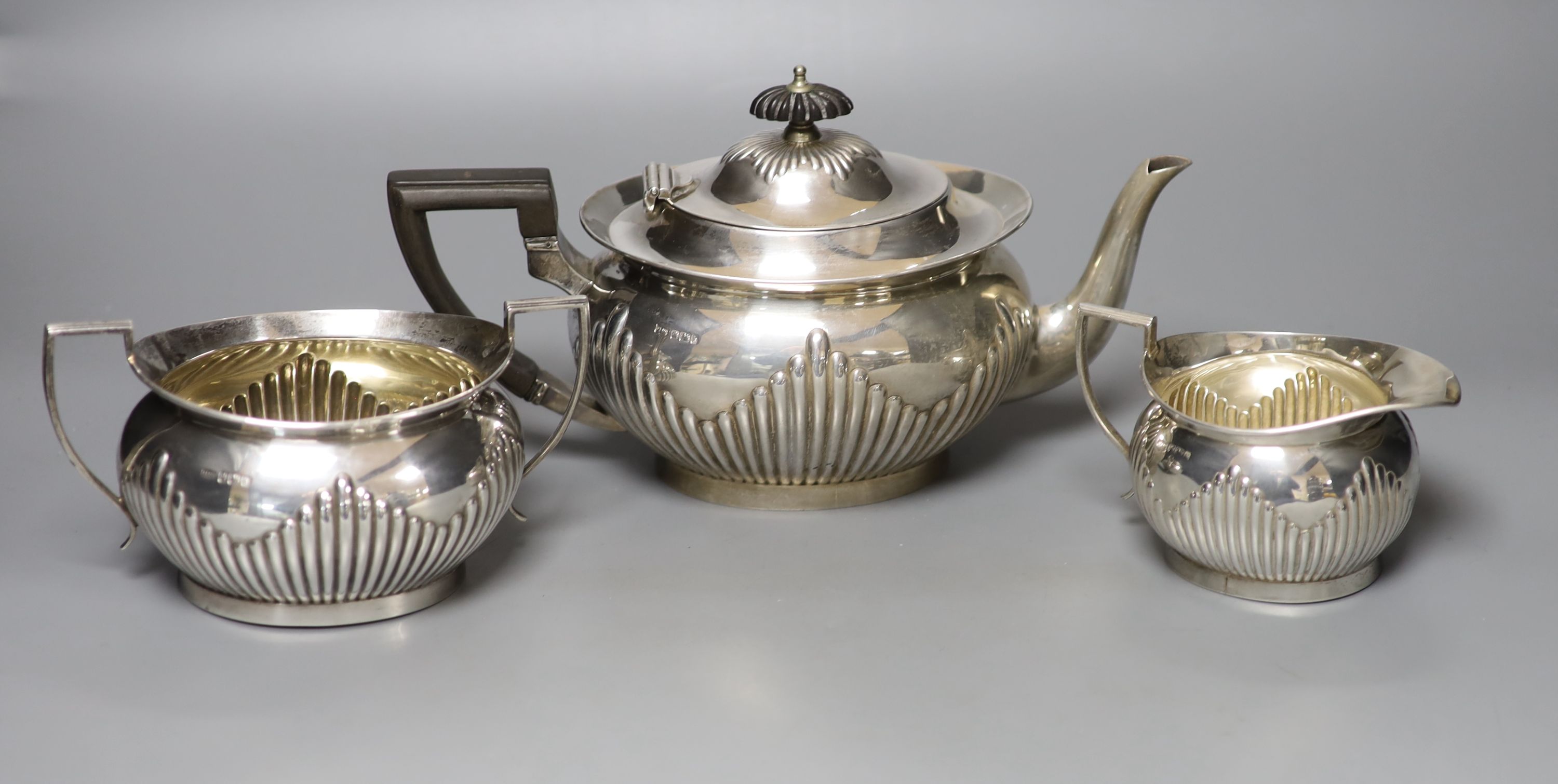 An Edwardian demi-fluted silver three piece tea set, Mappin & Webb, Sheffield, 1902